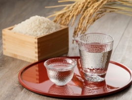 お米と稲とお盆に乗った日本酒の入ったお猪口とコップ
