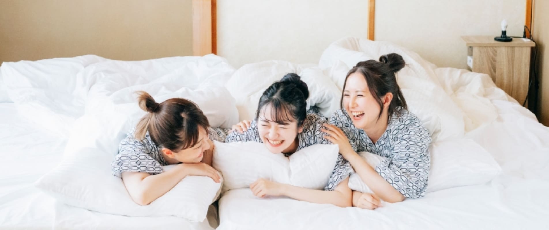 布団で話をしている女性たち